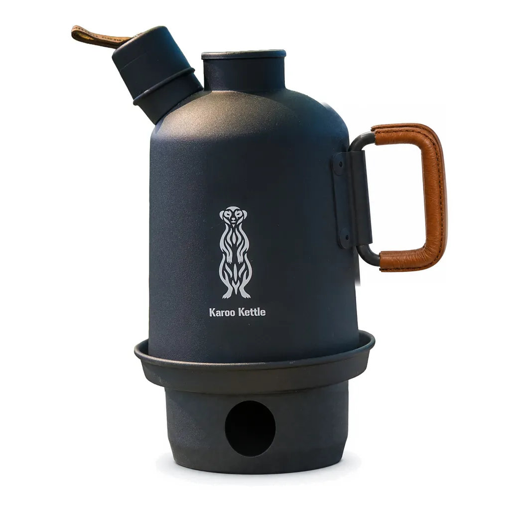 The matte black Karoo Kettle with its brown leather handle grip, on its fire pot, the meerkat mark in white on the body, cut out